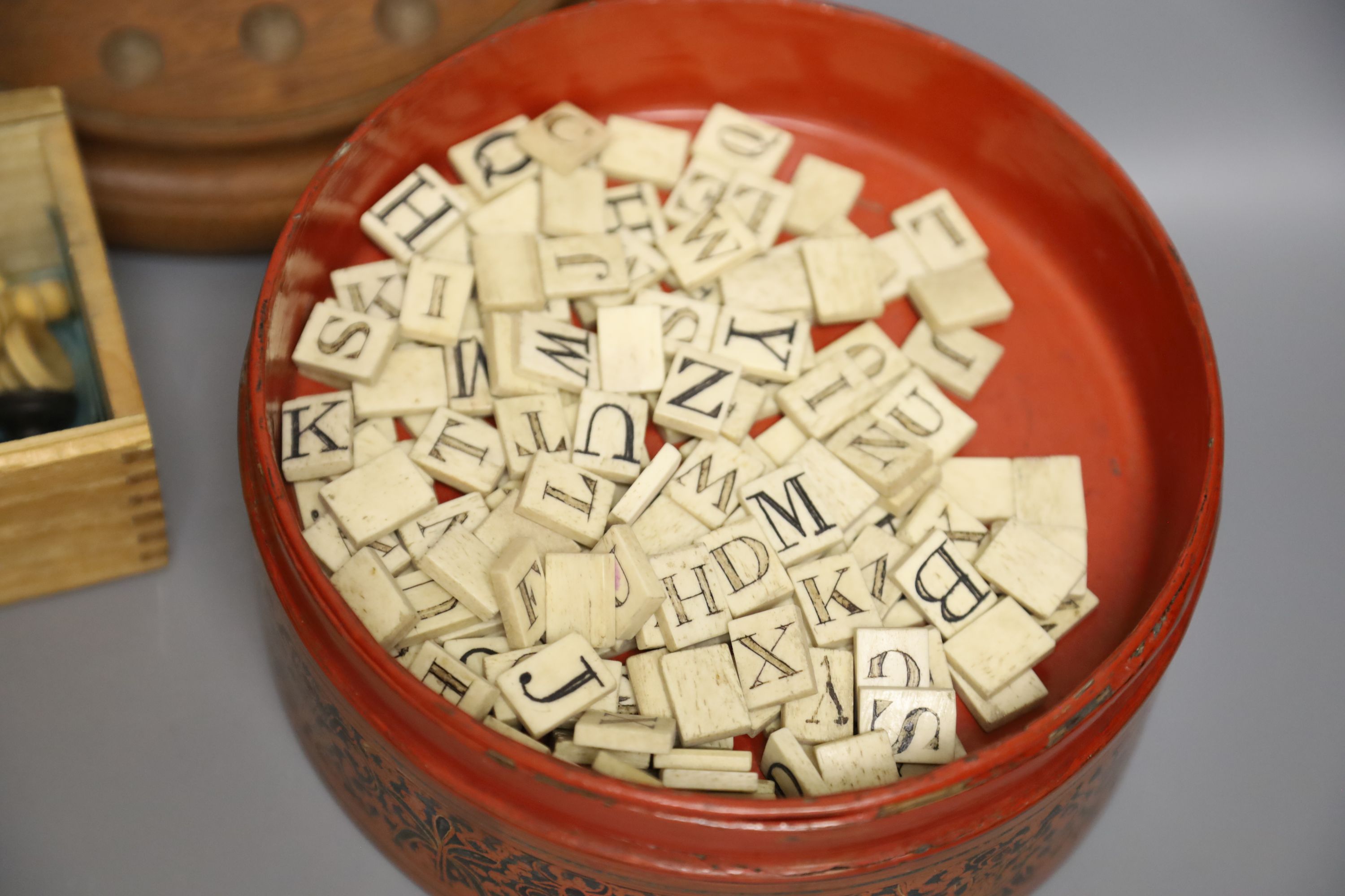 A quantity of marbles, boxwood chess pieces, a solitaire board and bone scrabble pieces and counters